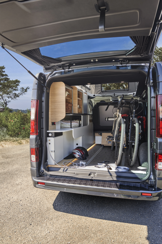Grande soute à l'arrière d'un van aménagé PIlote avec banquette coulissante et rangement